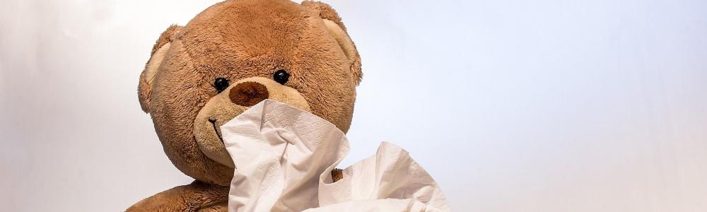 Teddybär mit Taschentuch, Spritze und Hustensaft