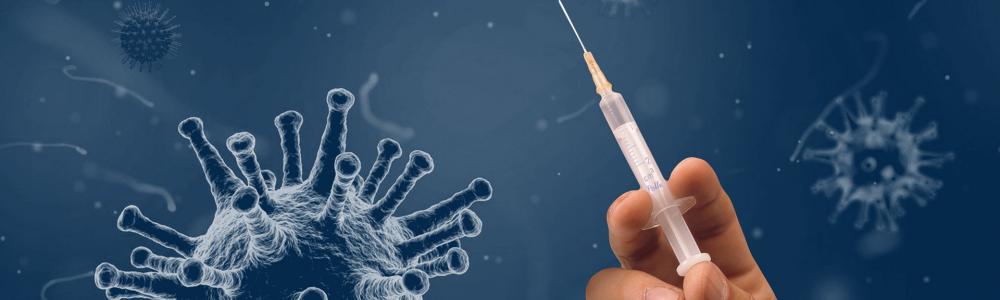 Hand hält eine Spritze, daneben das Coronavirus als blaue Kugel mit vielen Ausstülpungen in Großaufnahme