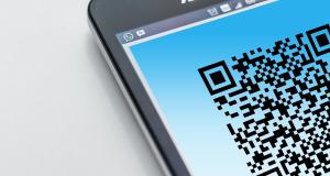 QR-Code auf einem Handy-Display, das auf einer hellen Oberfläche liegt